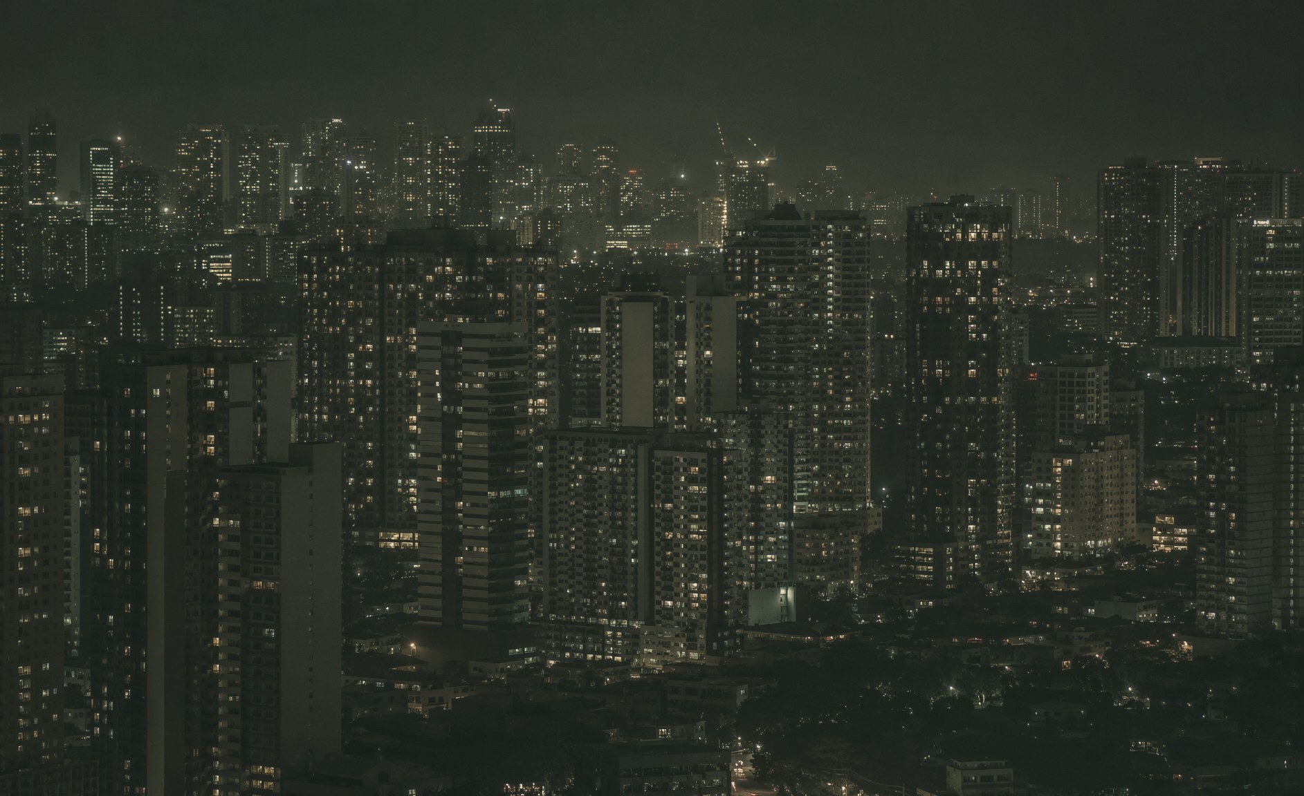 Manila after dark, thousands of lit windows across residential towers.